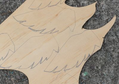 an off cut of ply wood with wing shapes drawn in pencil on it